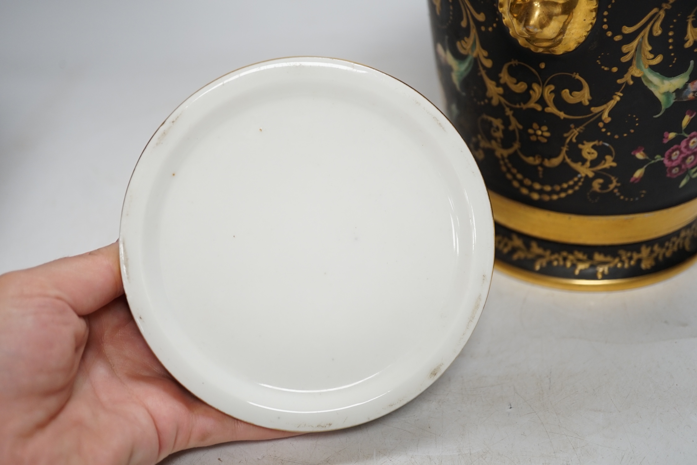 A pair of Paris porcelain cache pots and under dishes, black ground, floral and gilt decoration, 18.5cm high. Condition - both have wear to gilding and black ground, one pot has a star crack to base